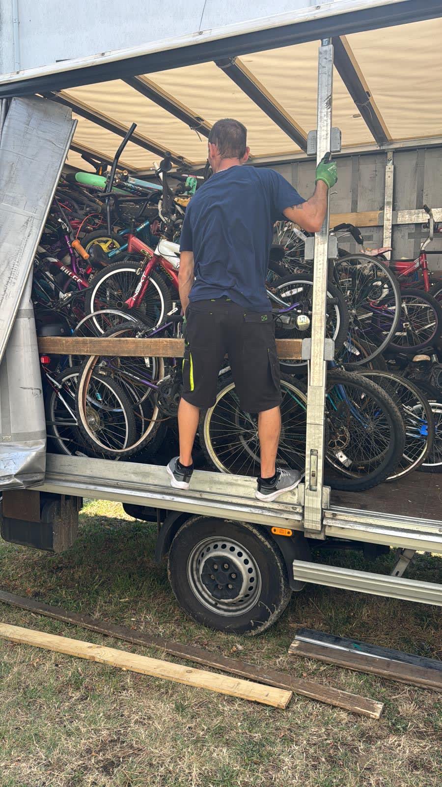 A volunteer standing inside the truck sorting through the packed bicycles.