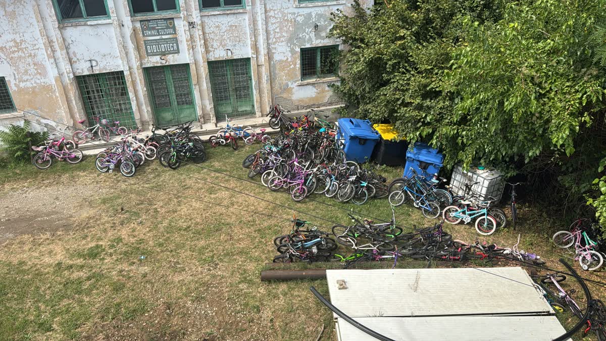 Bicycles lined up on the grass outside a community center in Romania.