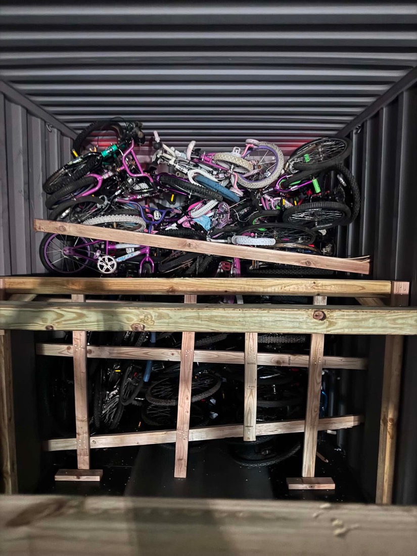 Wooden shelving inside the shipping container fully loaded with bicycles on every level.