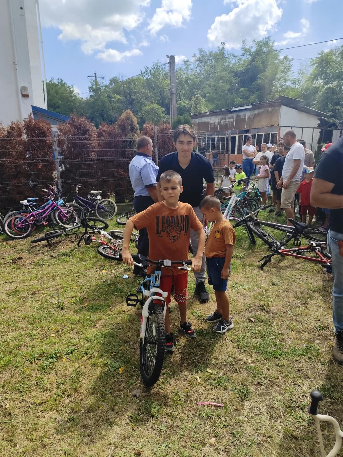 A boy giving a thumbs up while holding his new bicycle in Romania.