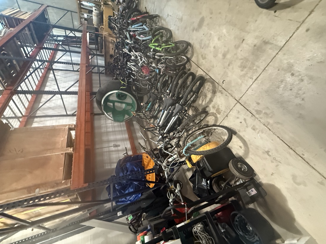 Rows of donated bicycles staged neatly along the warehouse wall.