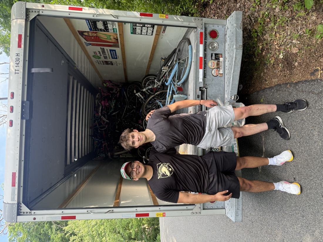 Two volunteers in front of the U-Haul, partway through loading donated bicycles.