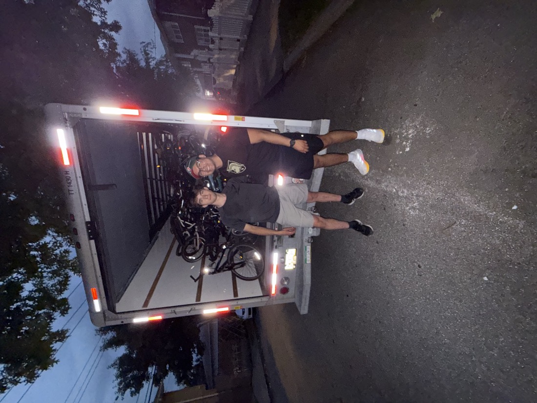 Volunteers with the truck at dusk, now packed with many more donated bicycles.
