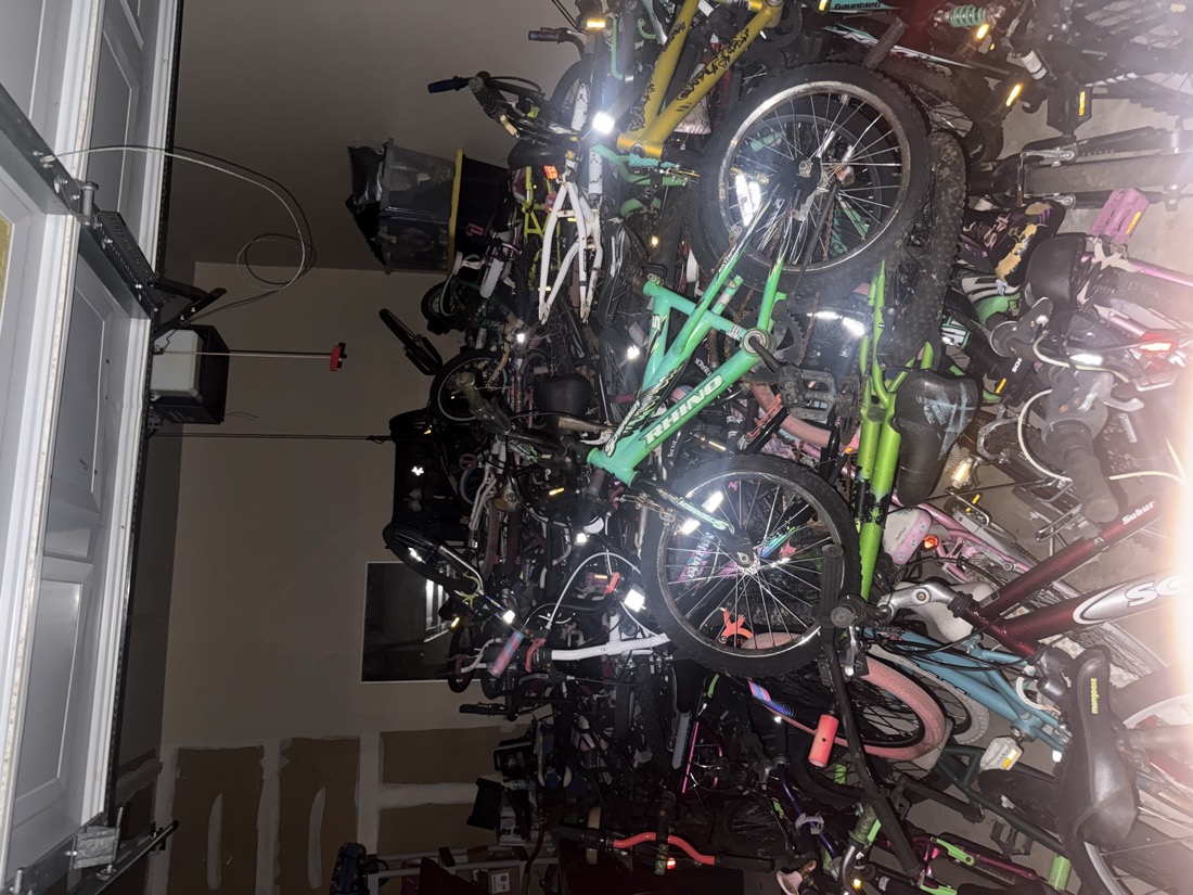 The full first haul of donated bicycles filling the garage from floor to ceiling.